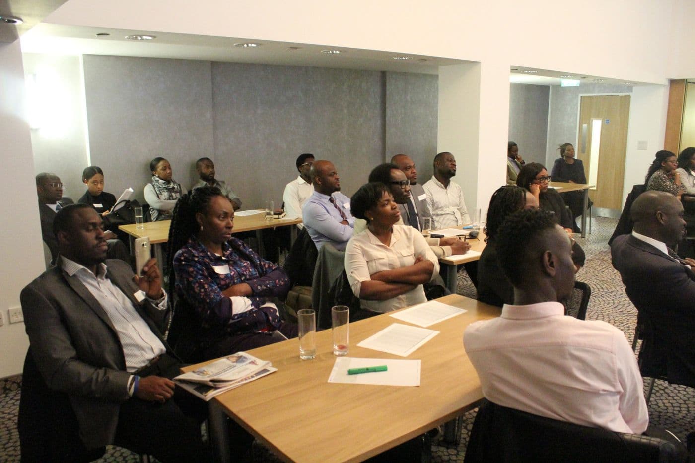 Attendees seated at tables, listening