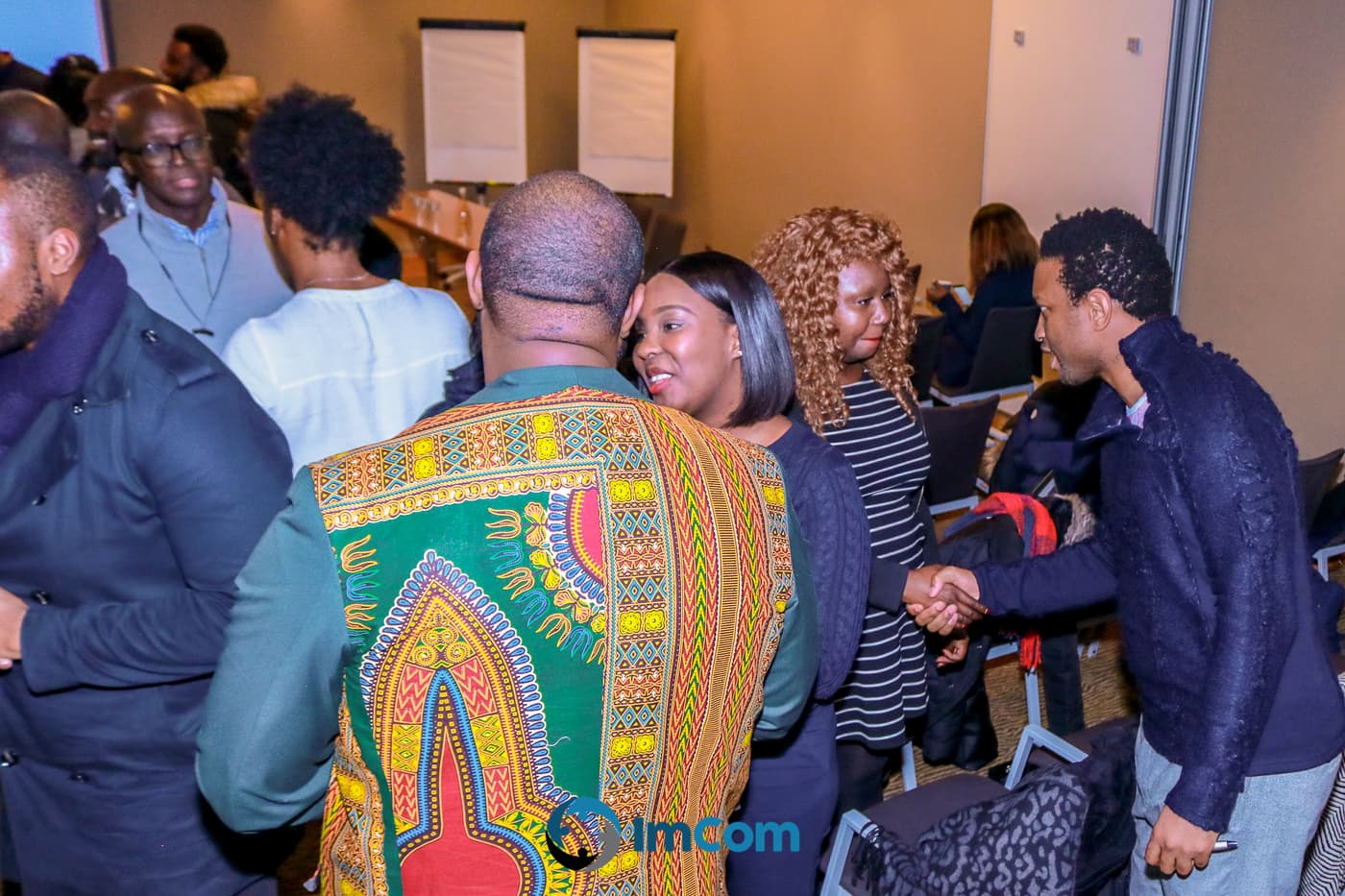 Attendees greeting each other in the crowd