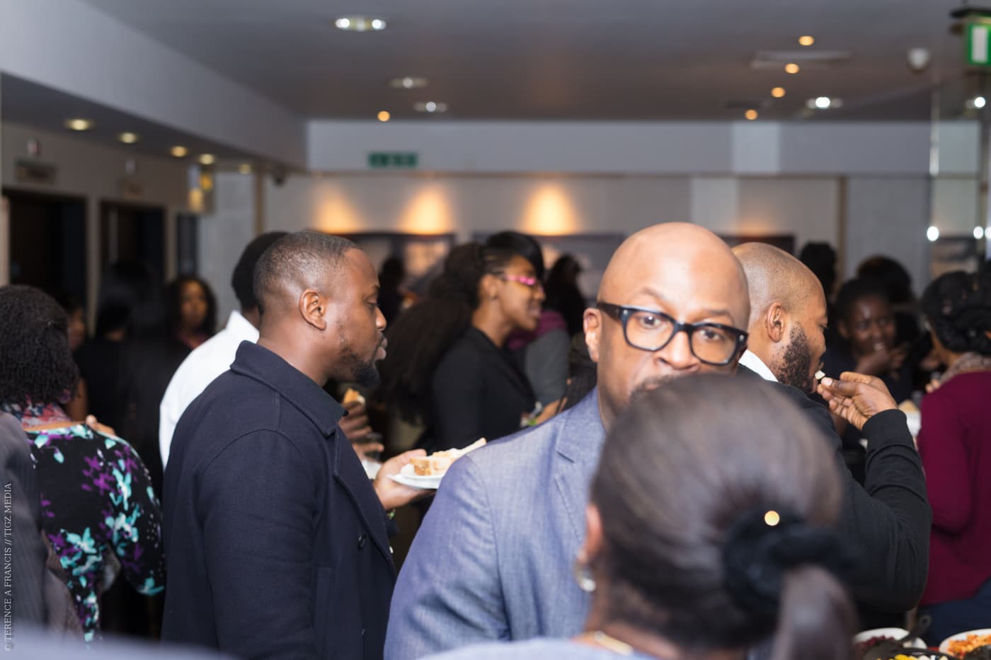 A group of attendees in conversation across the room