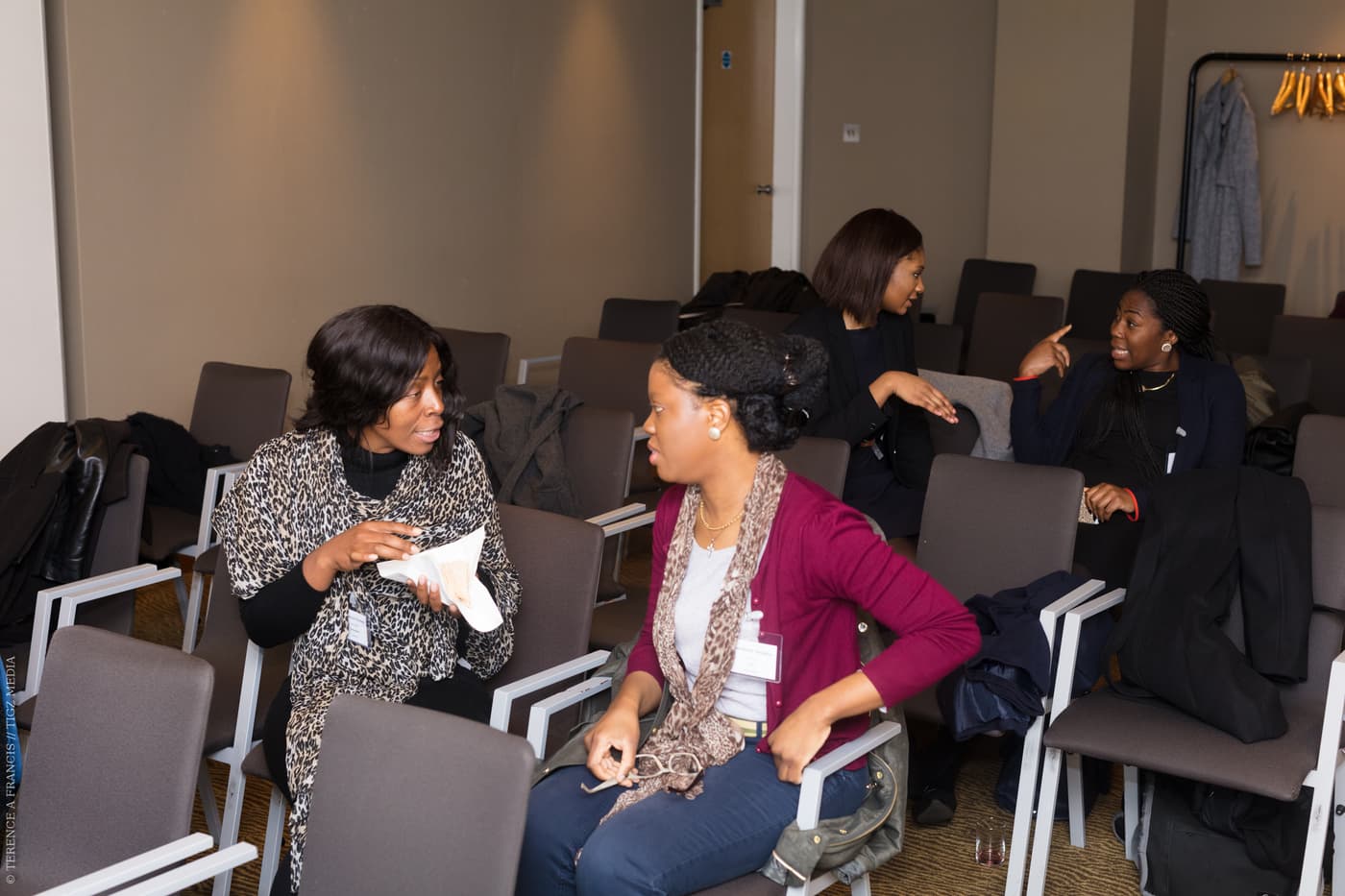 Two attendees talking across the seats
