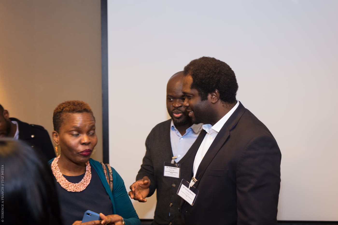 Three attendees in animated conversation