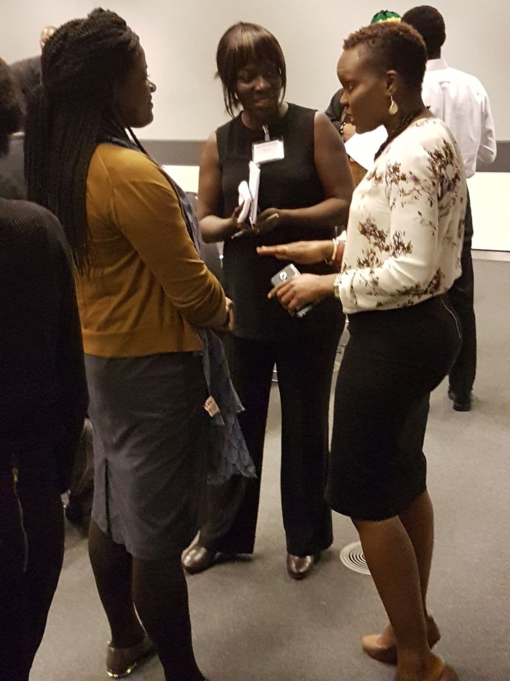 Three attendees in conversation after the talks