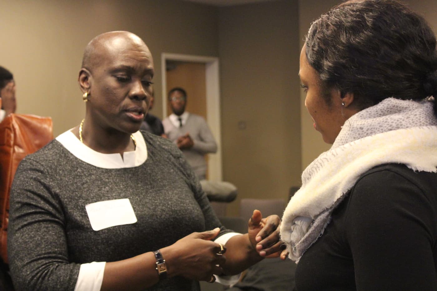 Two attendees greeting each other, name badges on