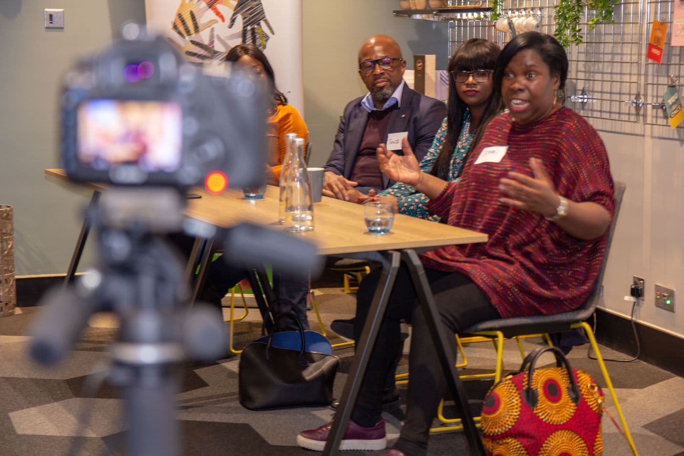 A camera on a tripod recording the panel