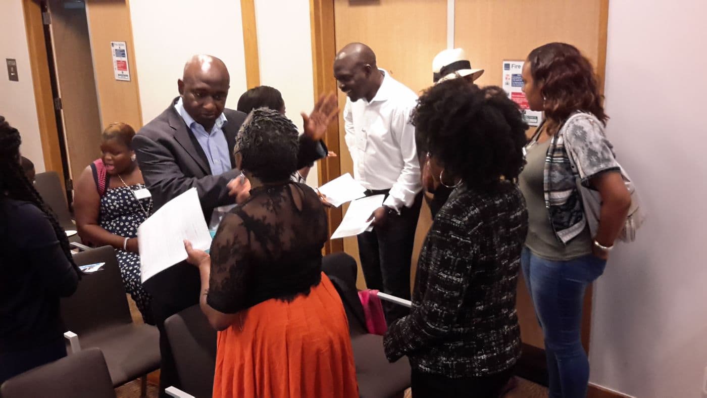 A group of attendees talking at the front of the room