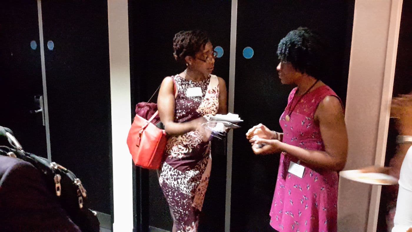 Two attendees talking by a doorway