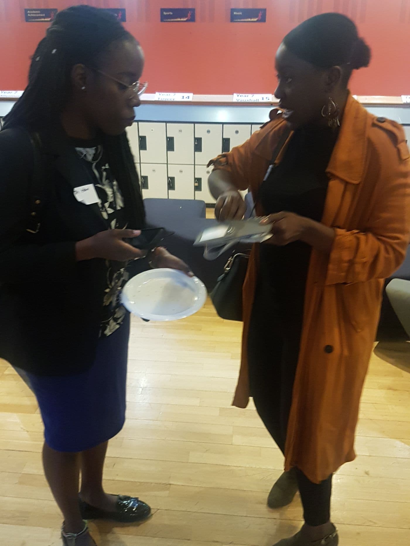 Two attendees in conversation, plates in hand