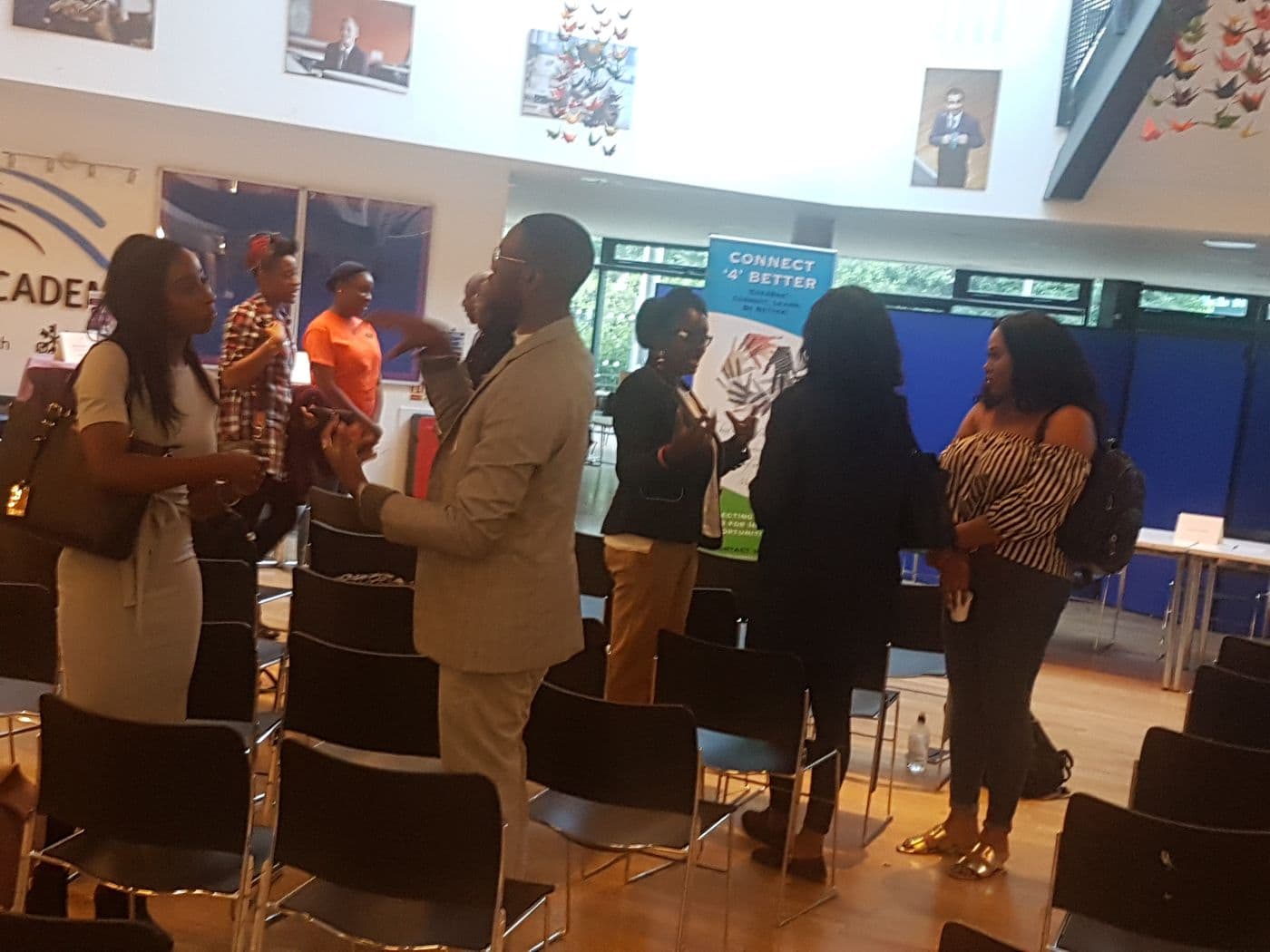 Attendees talking at the back of the room