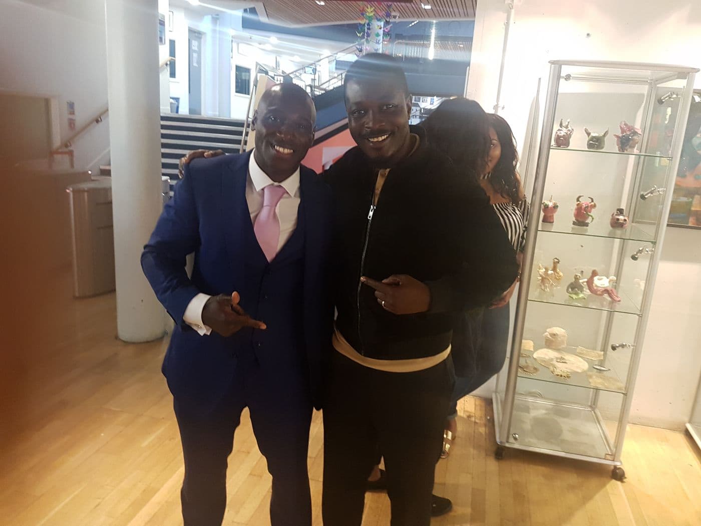 Two attendees in conversation beside a display case