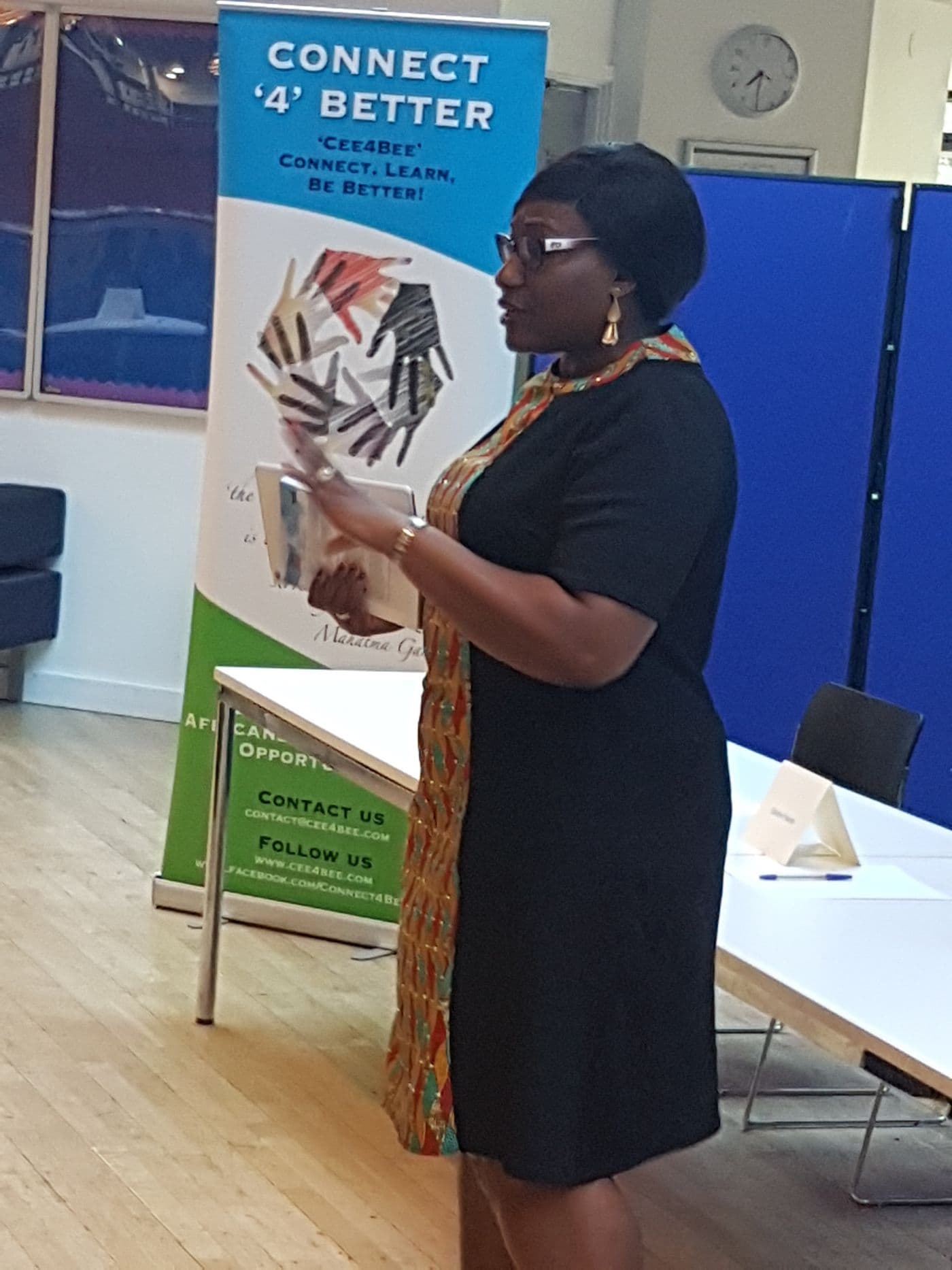 A speaker addressing the room beside the Connect ’4’ Better banner