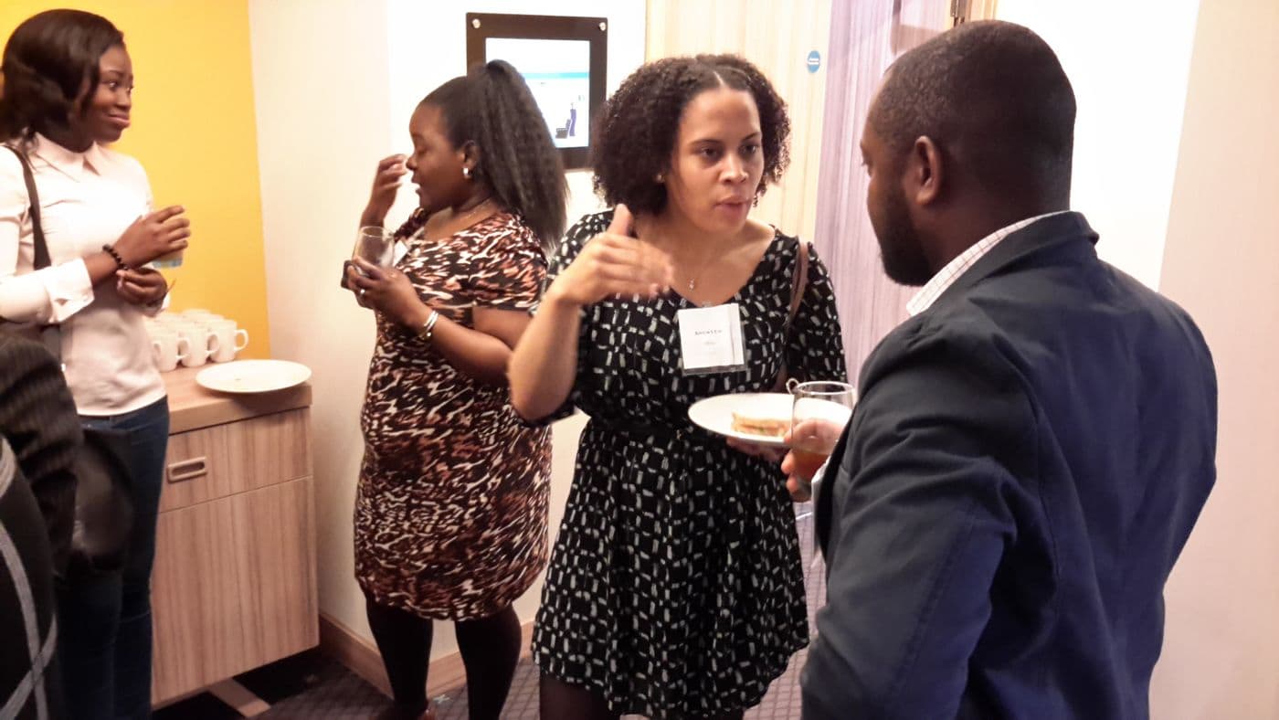Three attendees talking over refreshments