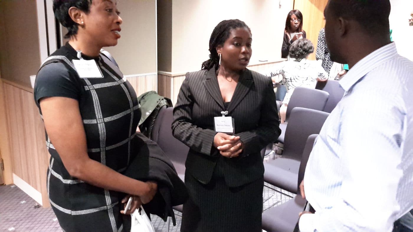 Three attendees talking, badges visible