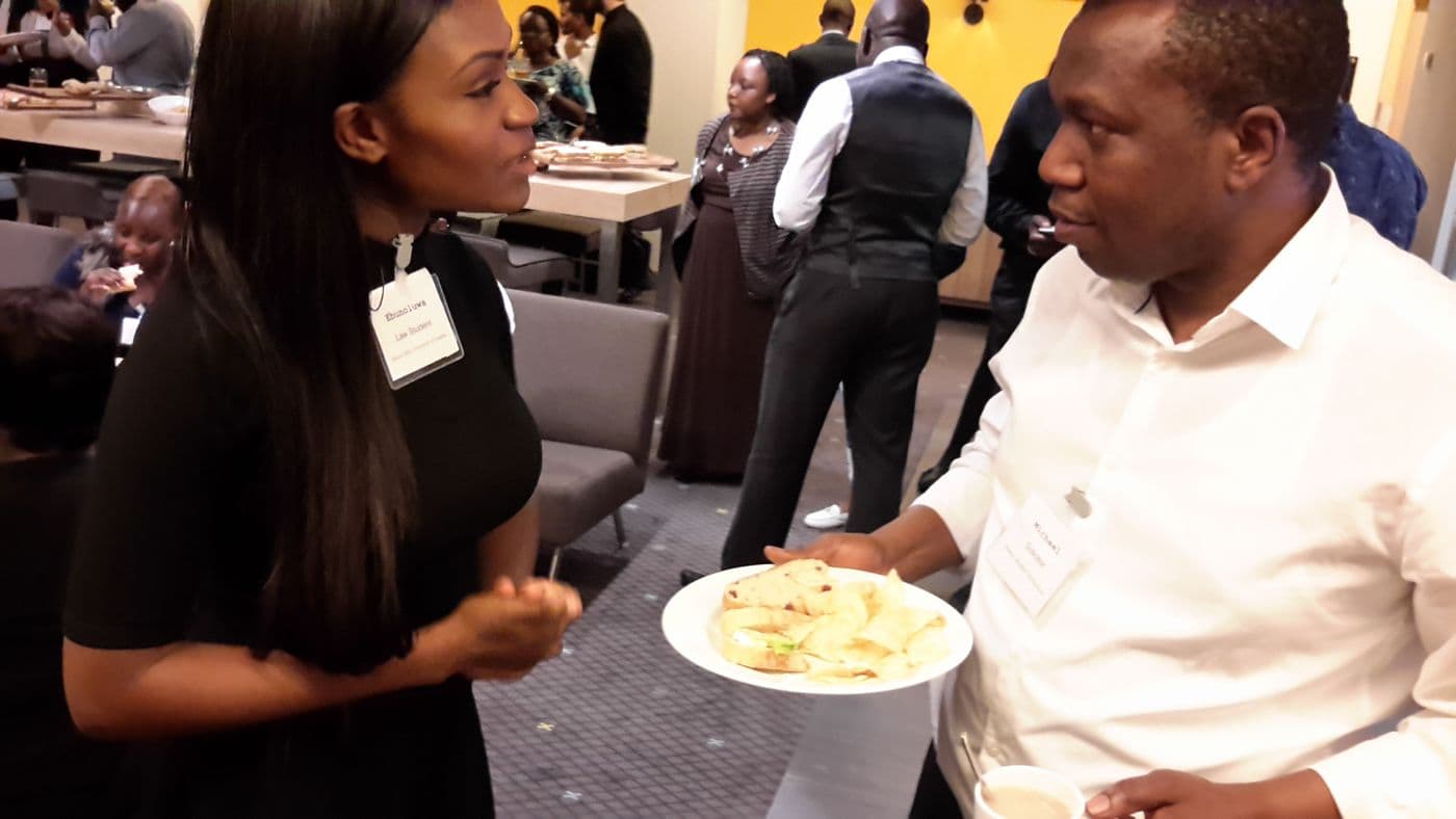 Two attendees talking over plates of food