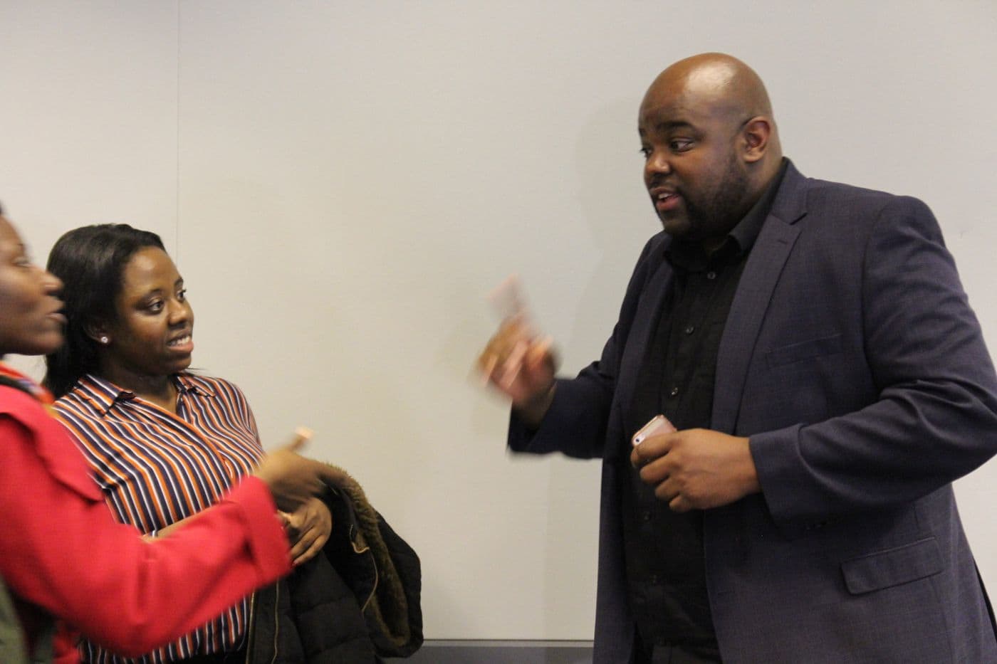 Two attendees in conversation at the side of the room