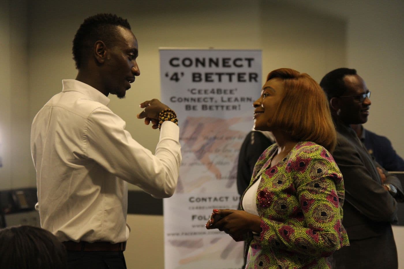 Attendees talking beside the Connect ’4’ Better banner