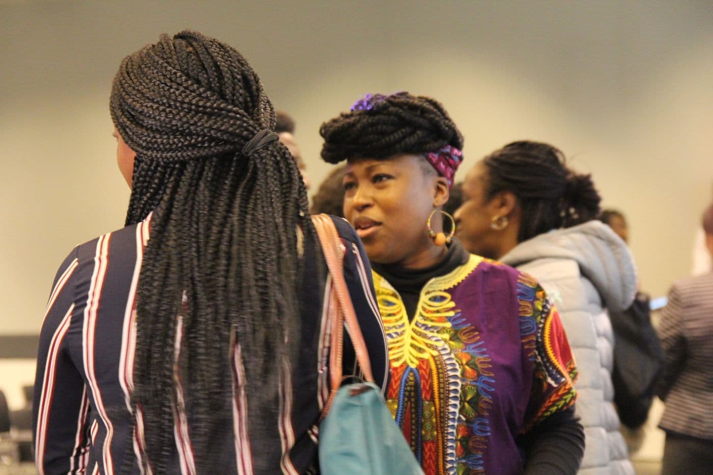 Two attendees in conversation in the crowd