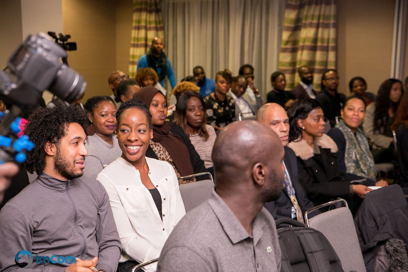 Attendees smiling from the middle of the room