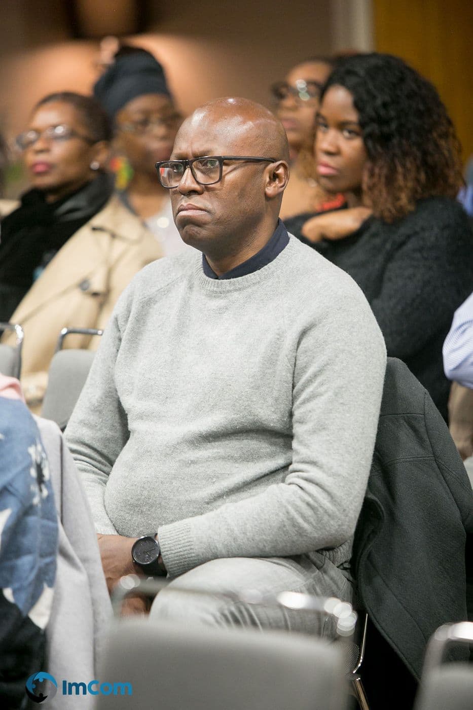 An attendee listening closely from the audience