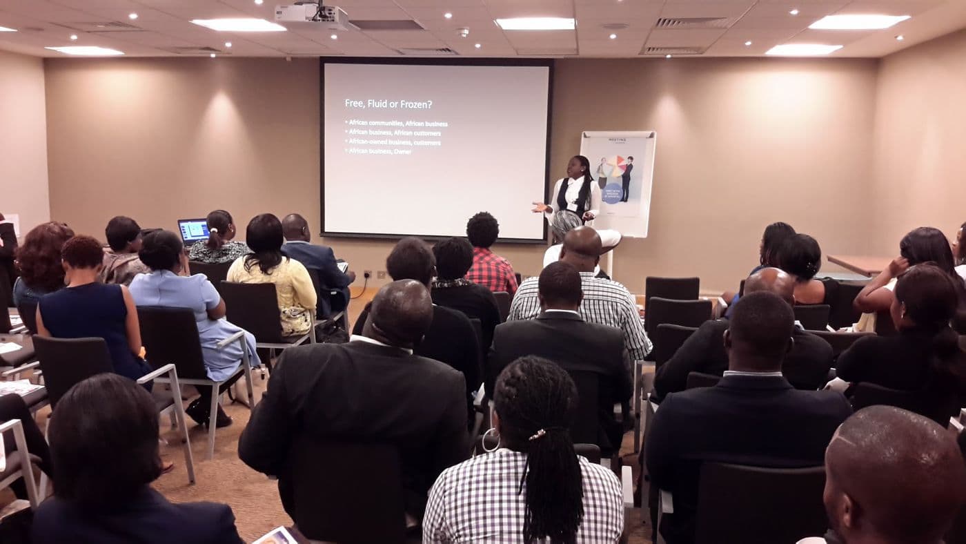 The audience seated, facing a presentation