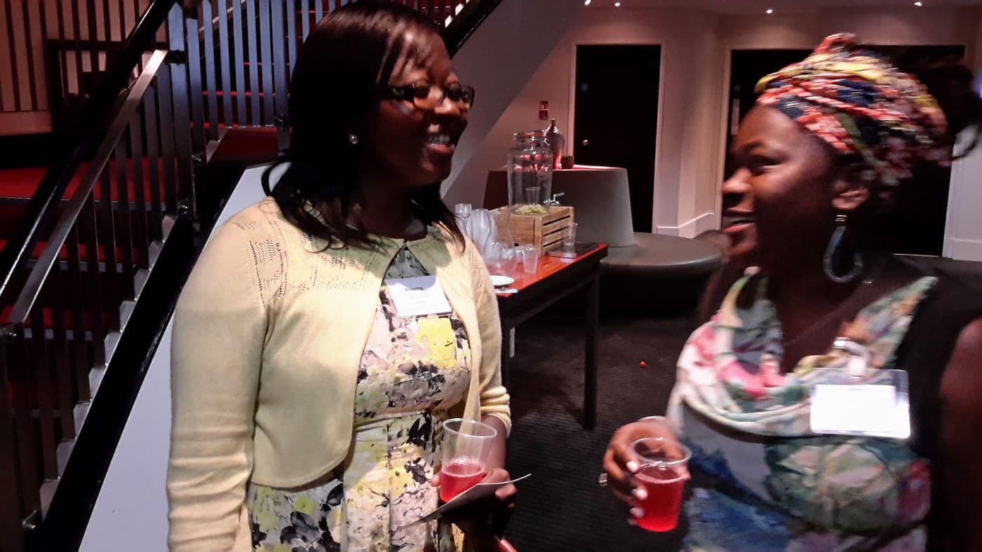 Two attendees in conversation by the stairs
