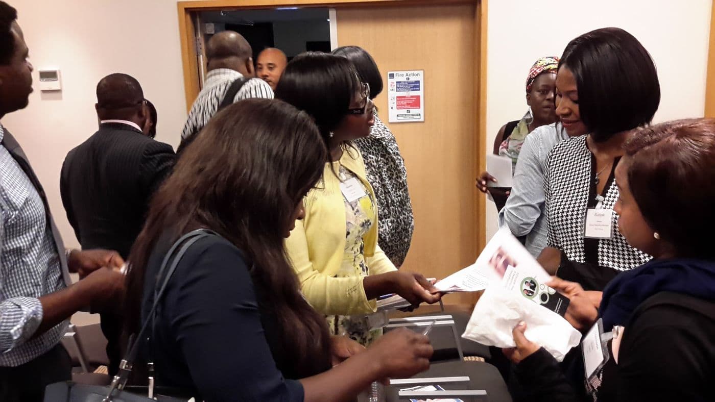 Attendees collecting handouts at the desk