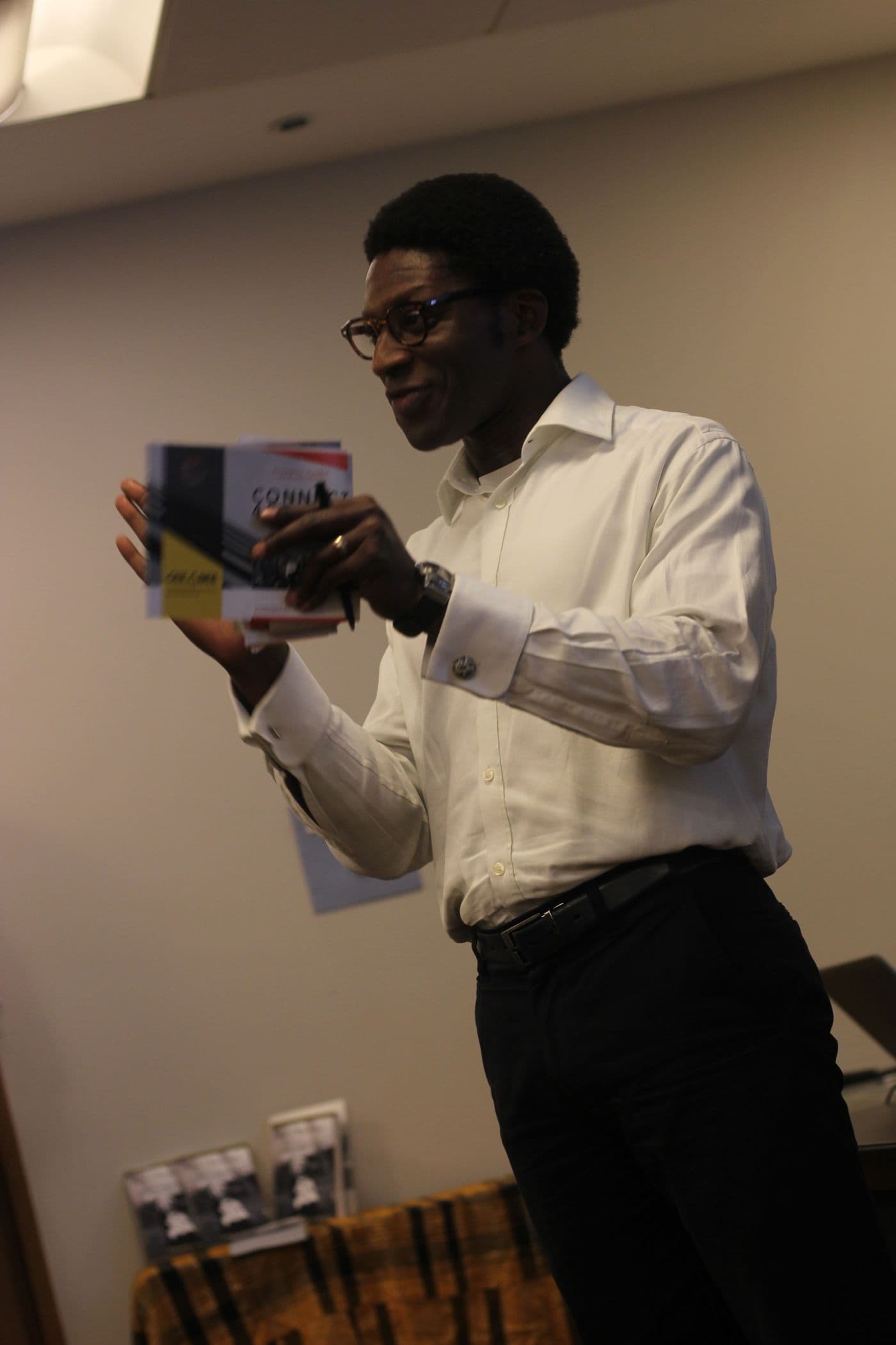 A speaker addressing the room, holding a book