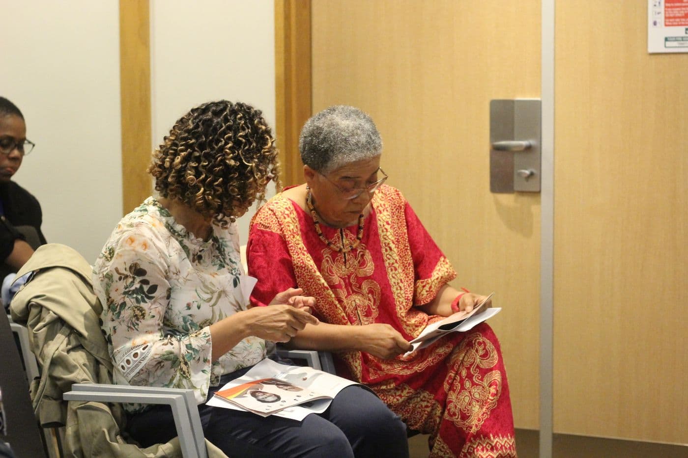 Two attendees reading the programme together
